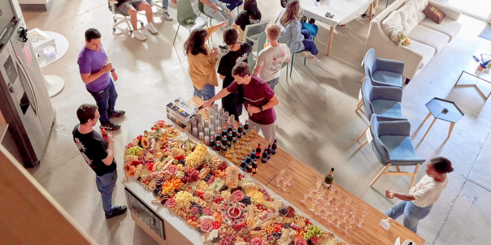 wholesome-goods-blog Extravagant and colorful charcuterie board laden with meats, cheeses, fruits, and snacks at a social gathering.