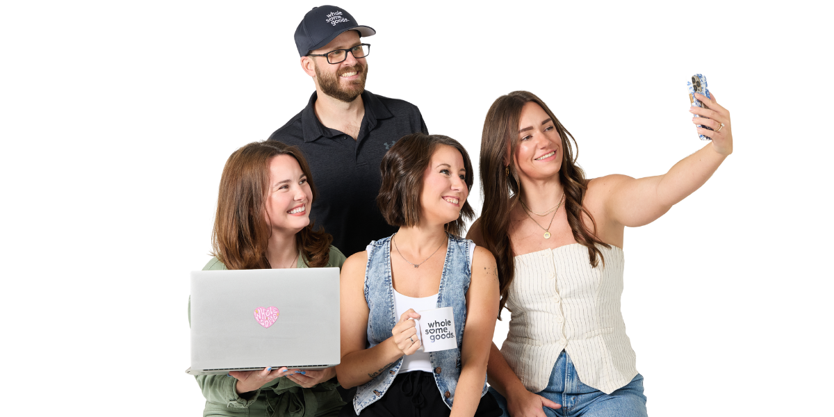 The Wholesome Goods Research & Content team taking a fun group selfie together, smiling and laughing with laptops and coffee mugs.